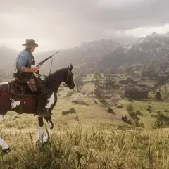 Kowboj na koniu z karabinem, patrzący na dolinę z osadą. To ujęcie z gry Red Dead Redemption 2 poradnik.