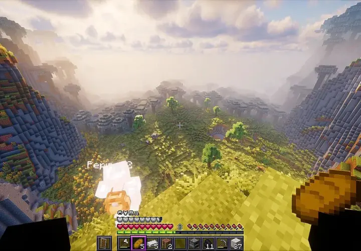 Widok z góry na dolinę w grze Minecraft. Gracz, Pepin, stoi na zboczu, a przed nim rozciąga się krajobraz z drzewami i budowlami. To lepsze mc!