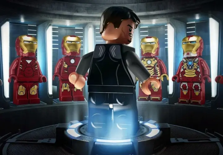 Tony Stark w swojej zbrojowni, otoczony przez różne wersje zbroi Iron Mana. To scena z gry LEGO Iron Man.