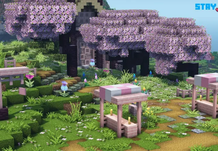 Urocza polana w grze Minecraft, gdzie drzewa kwitną na różowo, a ścieżki zdobią kamienie. Widać tu urocze stoiska i kwiaty, wszystko w stylu stay true texture pack.