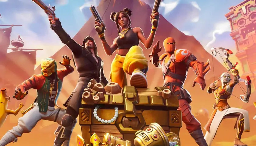 Postacie z gry Fortnite przy skrzyni pełnej skarbów. Idealne darmowe gry na PS4 dla fanów akcji i przygód.