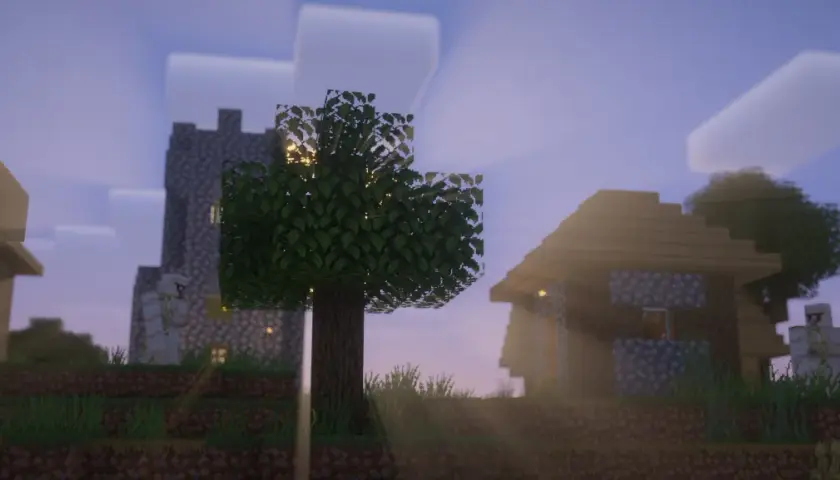 Wioska w Minecraft z vanilla plus shaders. Słońce przebija się przez drzewa, oświetlając kamienne domy i wieżę.