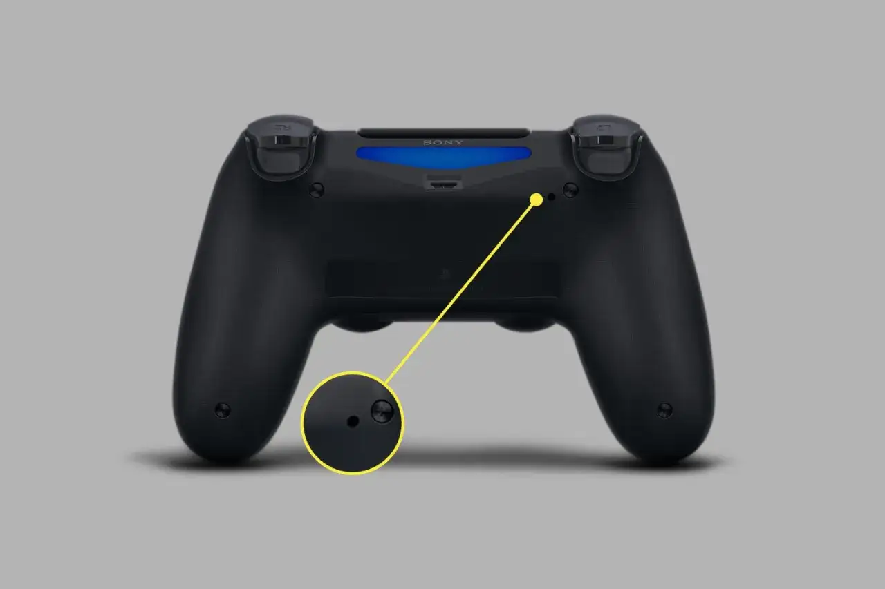 Czarny pad PS4 z widocznym przyciskiem resetowania. Dowiedz się, jak zresetować pada PS4, naciskając ten mały otwór.